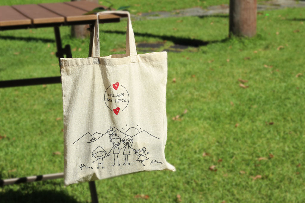 Baumwolltasche „Urlaub mit Herz" mit Familienmotiv an Parkbank, Gästegeschenk für Ferienwohnung und Ferienhaus